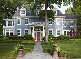 пластичный фасад каркасного деревянного дома в сером цвете с полукруглым портиком (входной группой)