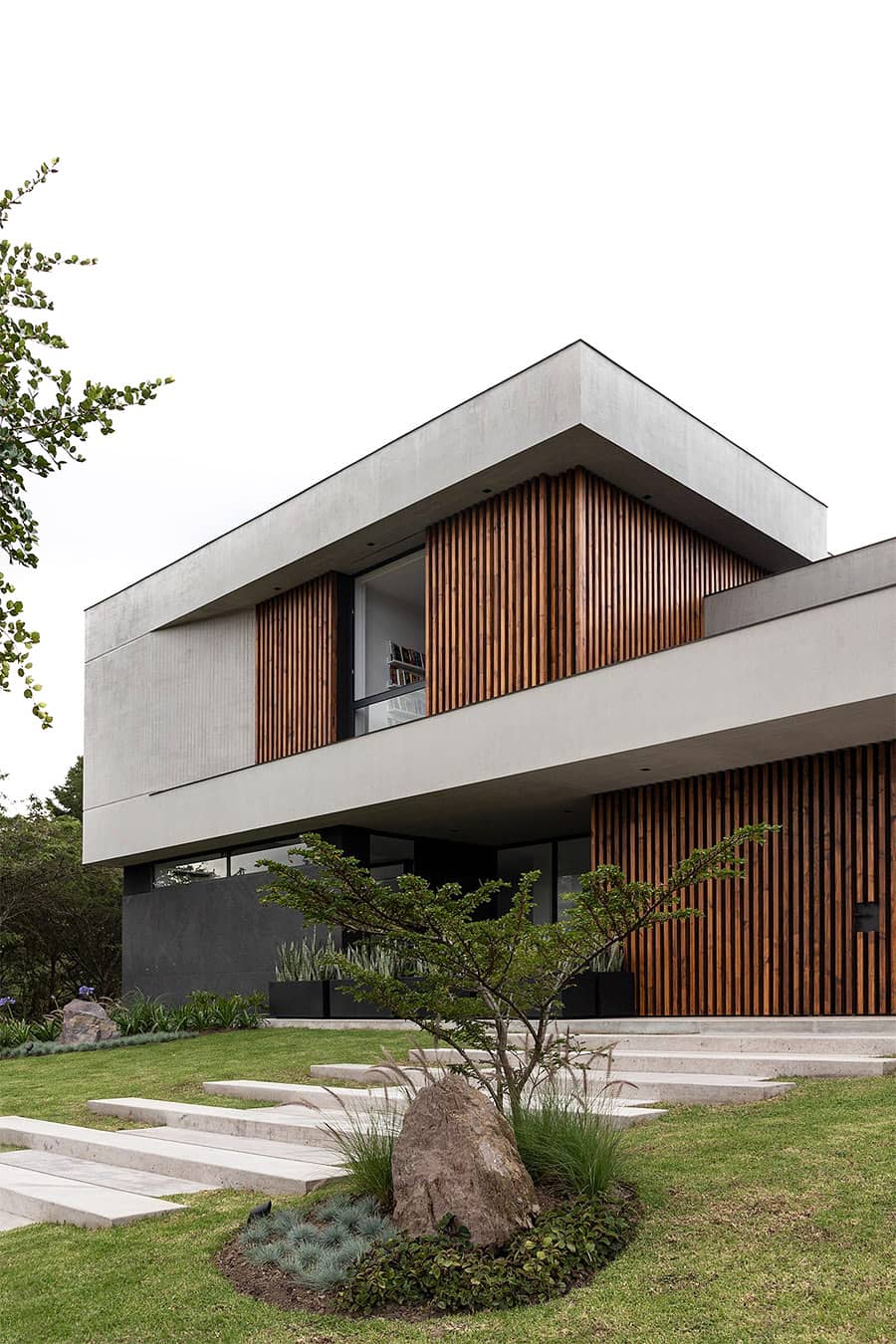 пример решения дизайна двухэтажного частного дома с использованием светлой двухфактурной штукатурки и реечного вентфасада из натуральной древесины теплого цвета - Casa Z | Najas Arquitectos