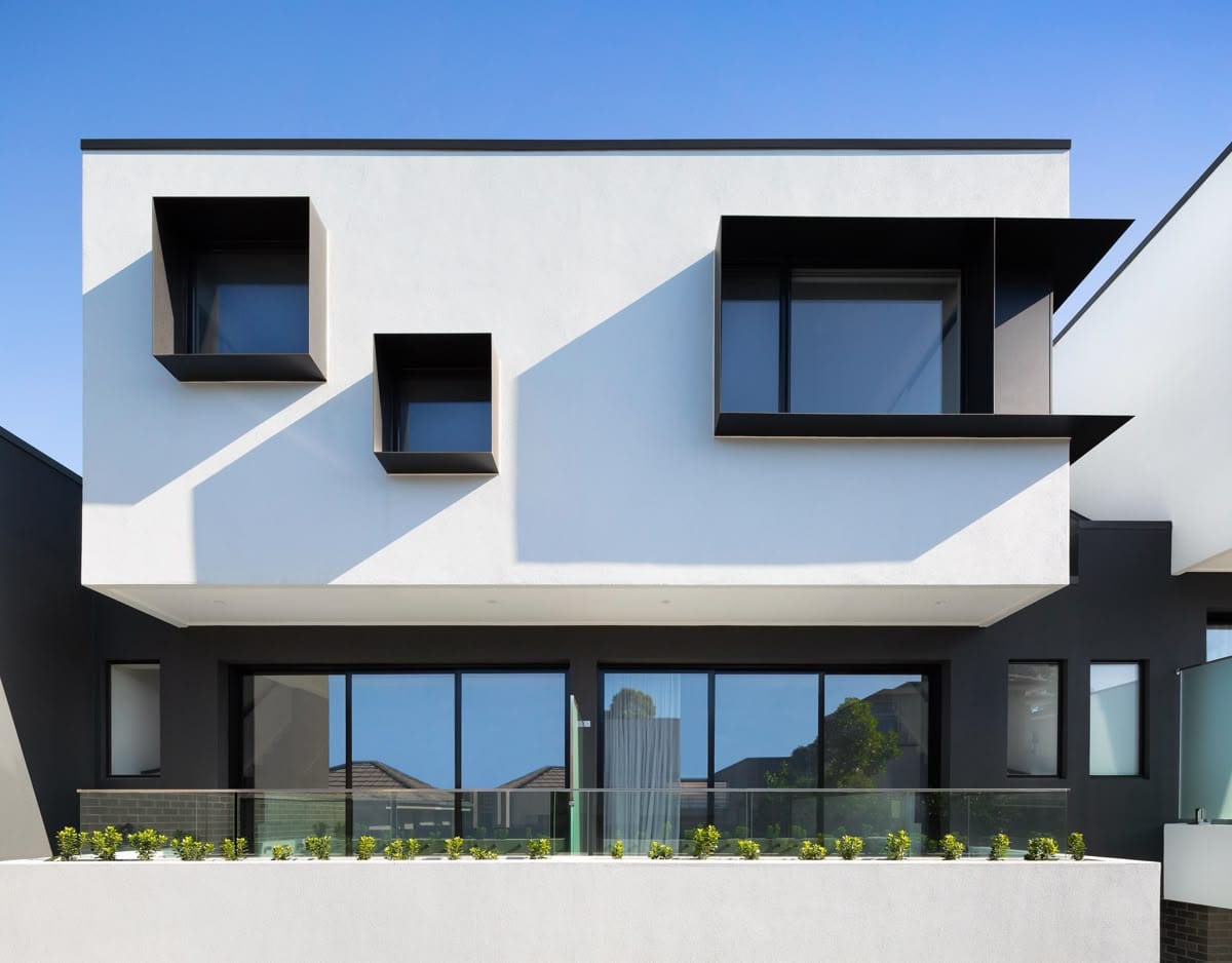 пример лаконичного монохромного фасада дома с выразительными акцентами на окна с выступающими металлическими откосами черного цвета
