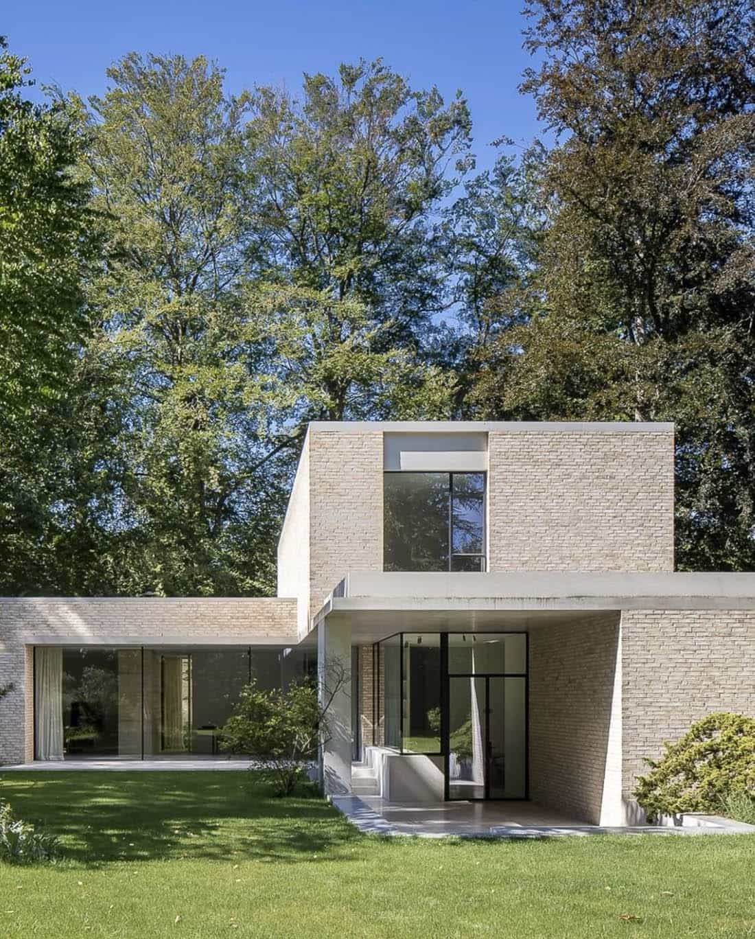 пример отделки фасада дома в современном стиле - панорамные окна, светлый клинкер и штукатурка