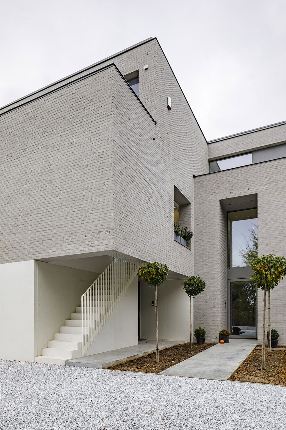 современный южный минимализм в молочном кирпиче и штукатурке с открытой лестницей