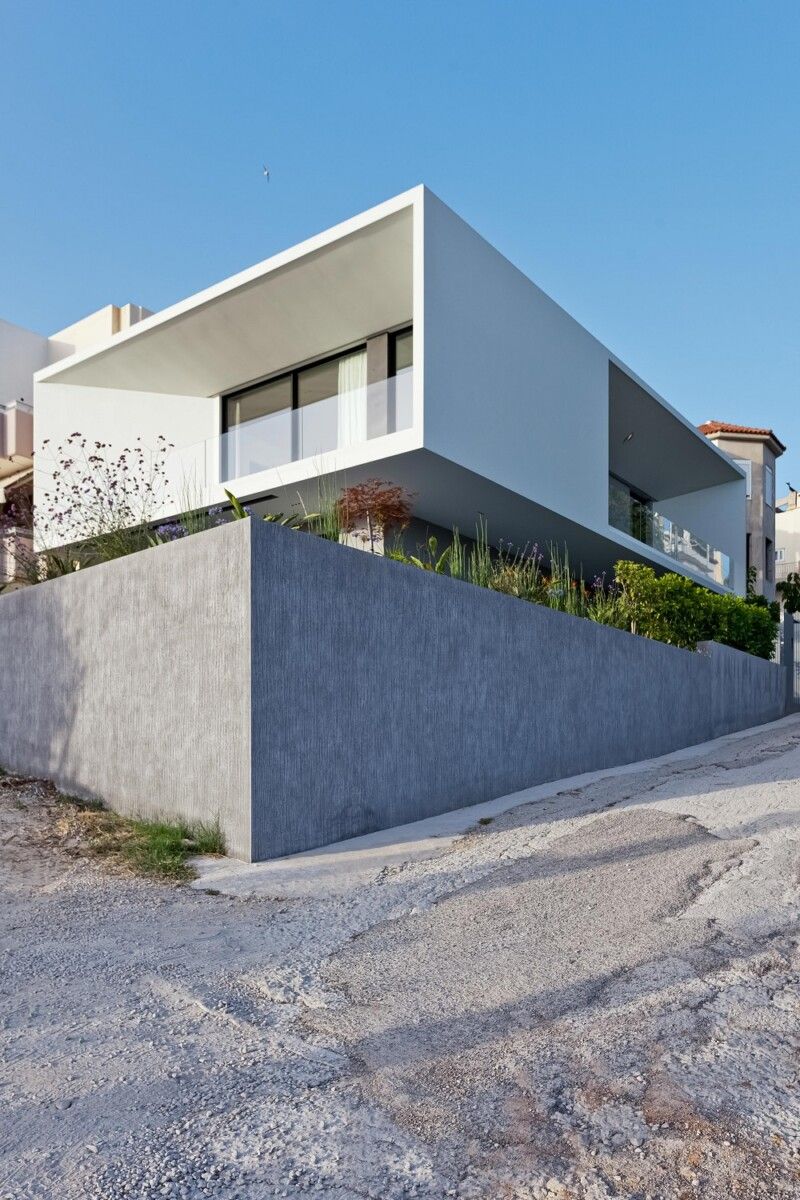 стильный лаконичный фасад современного дома со скошенными стенами балконов