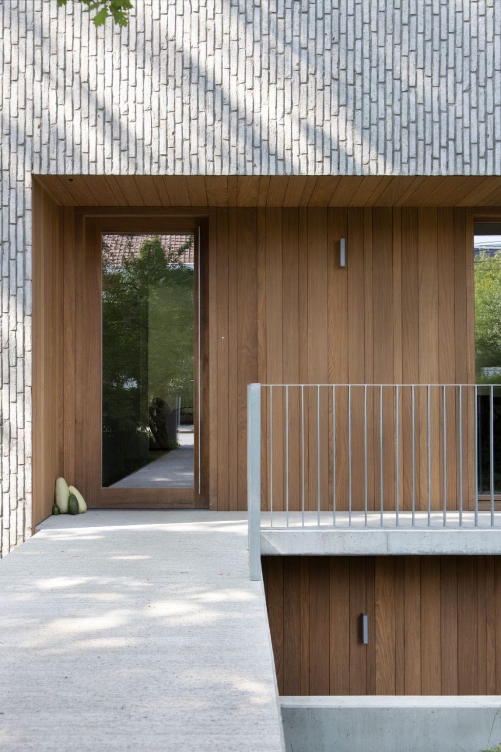 пример современной отделки белой вертикальной клинкерной плиткой в сочетании с разношироким планкеном