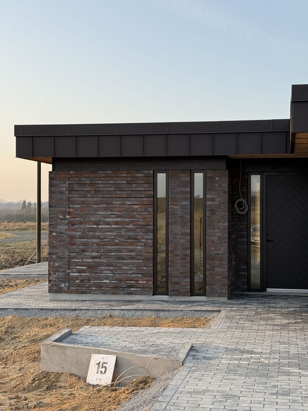 Одноэтажный дом с плоской крышей и отделкой фасадов коричневой ригельной клинкерной плиткой