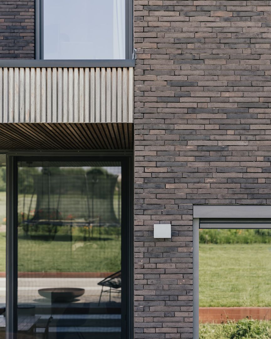 сочетание коричневого клинкера и белых реек на фасаде с серыми окнами