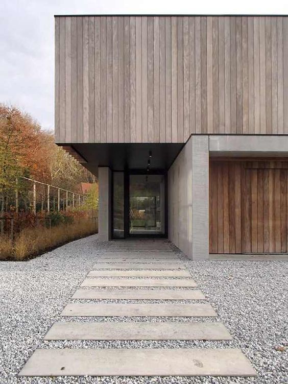 фасад из вертикального планкена в сочетании с бетонными поверхностями в дизайне лаконичного современного частного дома