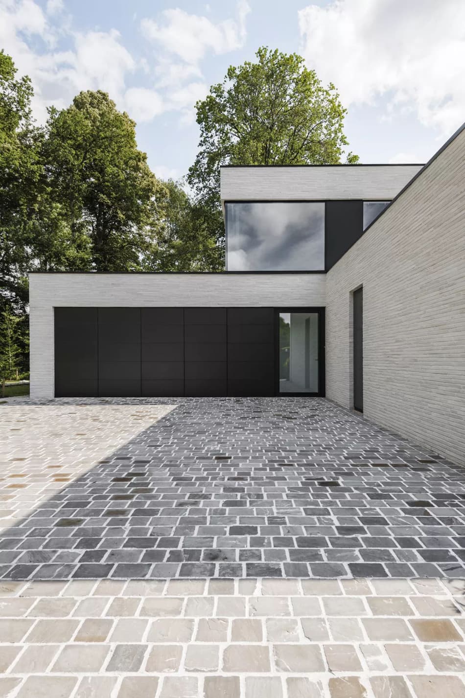 необычная раскладка в клетку композитных панелей на клинкерном фасаде современного двухэтажного дома с плоской крышей