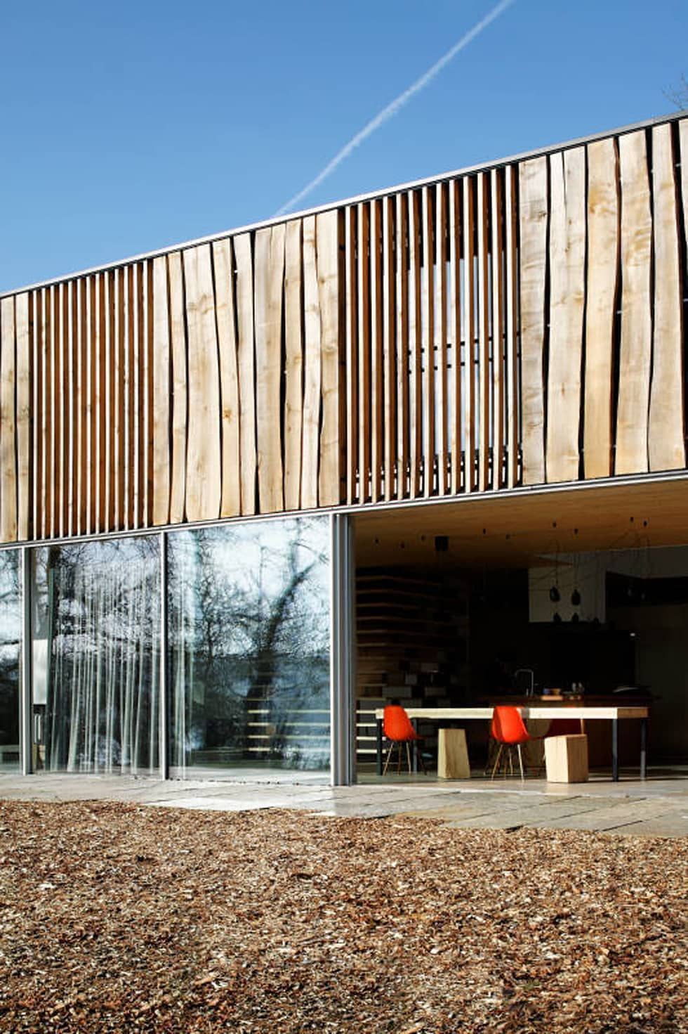 весьма стильная деревянная отделка современного двухэтажного дома с большим остеклением первого этажа