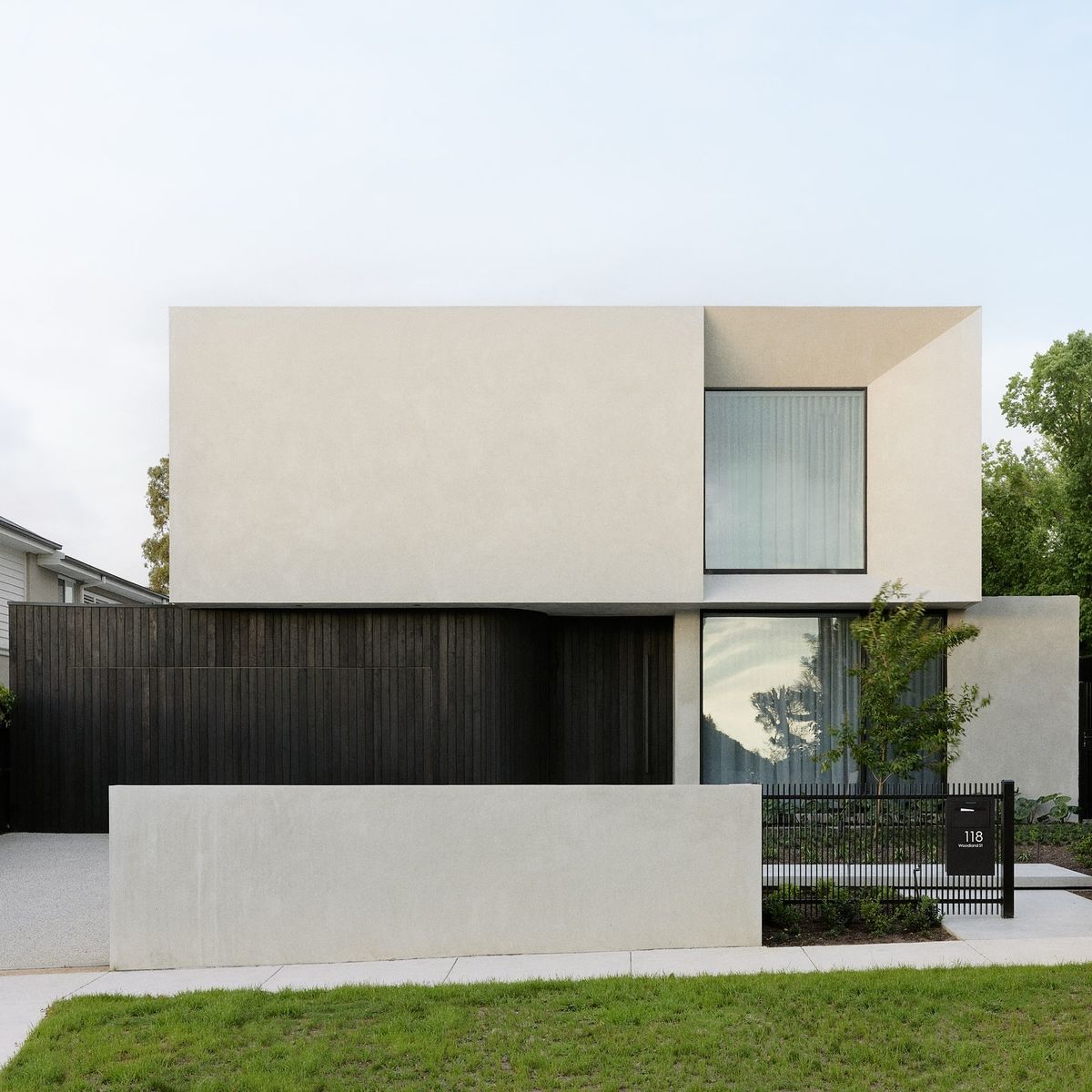 нельзя не влюбиться в чистоту пропорций и объемов этого небольшого современного дома - минималистичный дизайн фасада сочетает в себе контрастную вертикальную раскладку из досок черного цвета и белый штукатурный фасад