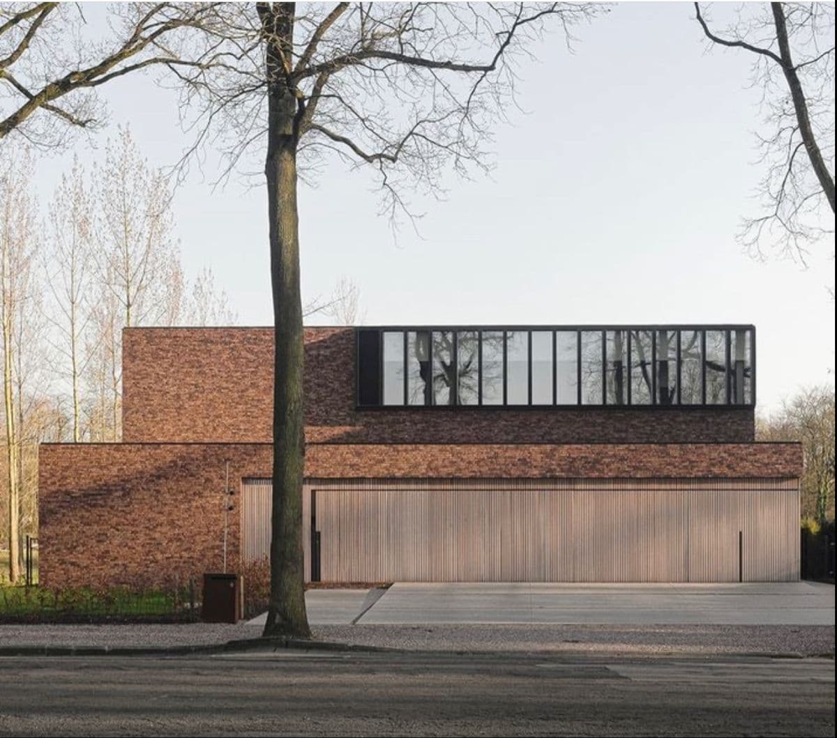 клинкерный фасад в современной архитектуре частных домов часто сочетают с акцентной вертикальной деревянной отделкой (доска, планкен, рейки, бруски) натуральных цветов