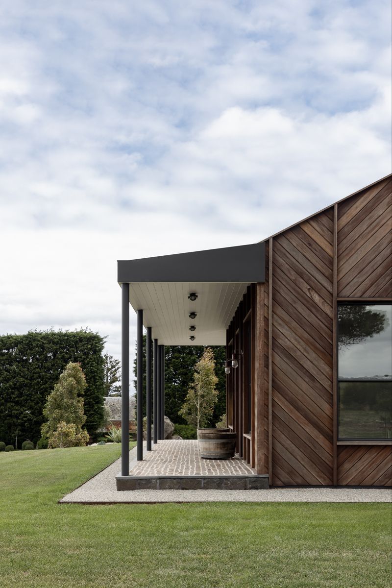 современный фасад одноэтажного дома с вертикальными ребрами и заполнением доской в виде елочки