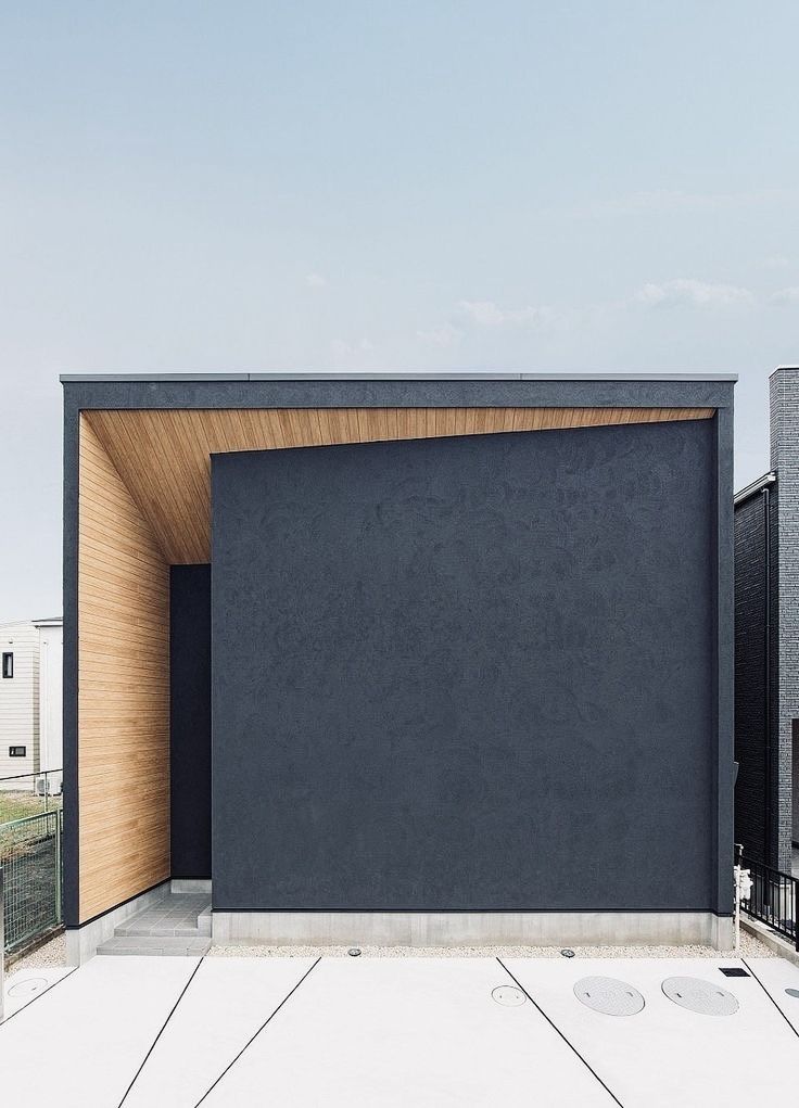 дизайн фасада этого одноэтажного современного дома-куба хорошо может подойти интровертам, любящим натуральное дерево и красивую штукатурку цвета графит