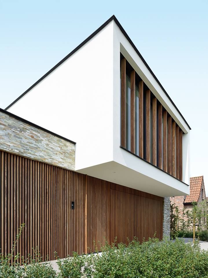 современный фасад двухэтажного дома с плоской крышей в минималистичном духе - белая штукатурка, алюминиевые ламели под дерево, рейки из лиственницы и искусственный камень