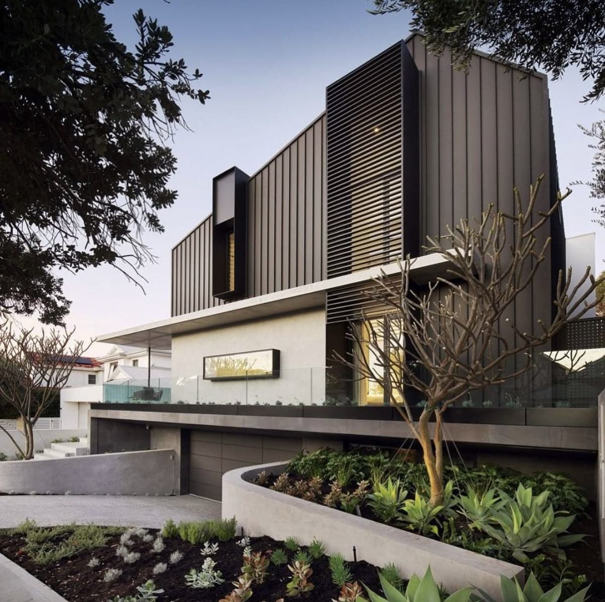 современный фасад - ломаная линия крыши, выступающие акцентные обрамления окон и четкий ритм фасадного металлического фальца