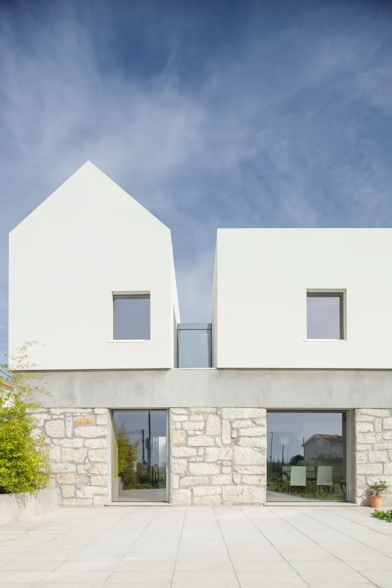 современный лаконичный дом в средиземноморских мотивах - белоснежная декоративная штукатурка и грубый крупноформатный натуральный камень натурального светло-бежевого цвета создают уютный и гармоничный фасад