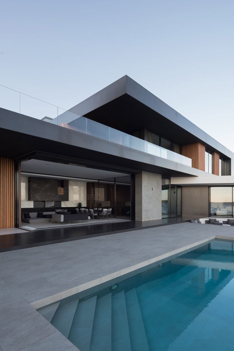 фасад современного дома с бассейном - большие консольные свесы, стеклянное ограждение, натуральная деревянная отделка из рейки, крупноформатный керамогранит и панорамное остекление
