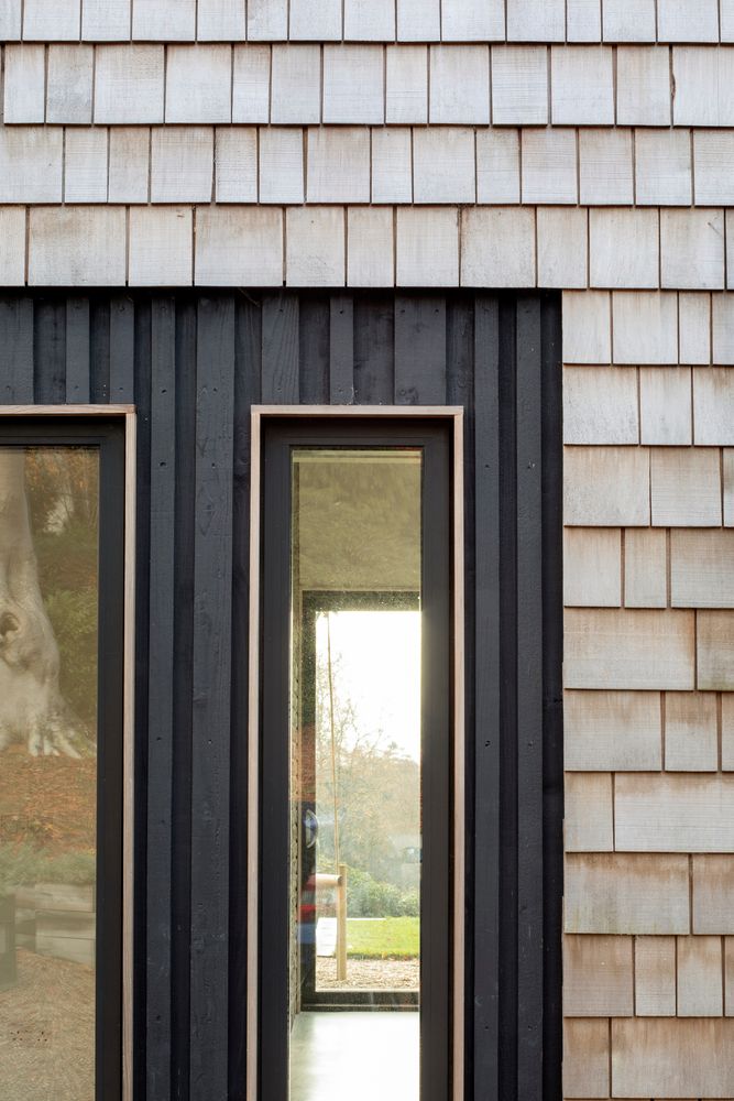 деревянный фасад из светлого гонта в сочетании с вертикальными графитовыми рейками и досками - еще один пример современной отделки фасадов