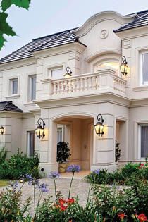 пример красивого светло-молочного оштукатуренного фасада особняка с балконом над главным входом и балясинами в ограждении