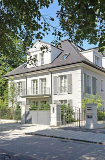 изящное решение двухэтажного таунхауса с мансардой и светло-серыми ставнями на окнах в стиле современной классики