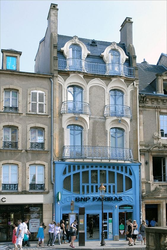 здание в стиле ар-нуво с серо-бежевым оштукатуренным фасадом и голубой входной группой