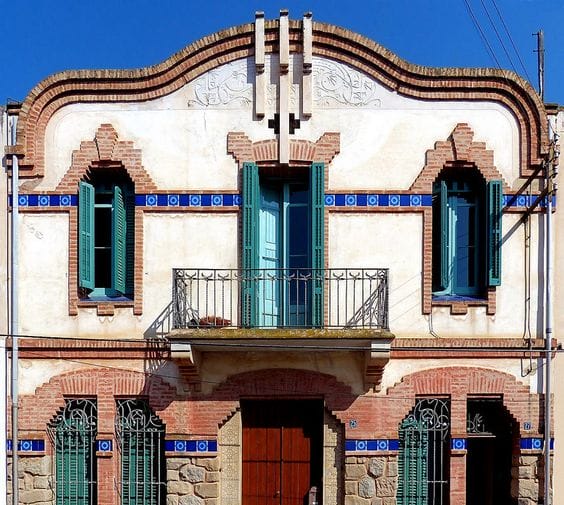 белый красивый штукатурный фасад европейского здания с обрамлениями из красного кирпича эпохи модерна