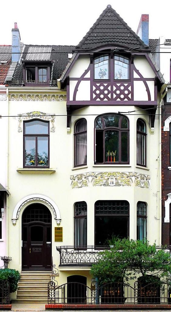 фото варианта отделки здания в стиле европейского модерна с использованием штукатурки и элементами фахверк