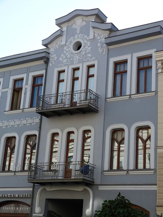 фасад в стиле ар-нуво с применением штукатурки серого цвета в сочетании с белым декором