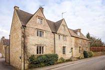 простая архитектура деревенского английского дома с двумя фронтанами на главном фасаде