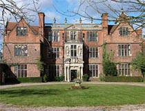 классический английский особняк из красного кирпича с центральной входной группой из светлого камня