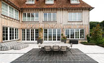 пример стильного фахверк дома с большой открытой зоной патио