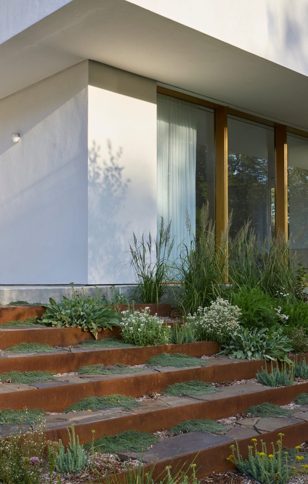 Высокие панорамные окна и раздвижные двери вновь связывают дом с окружающей средой, раскрывая виды на пруд, поля и лес.