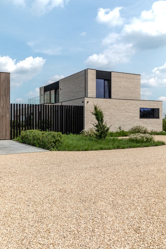 Анодированный черный алюминиевый профиль хорошо подчеркивает и дополняет архитектуру этого частного дома