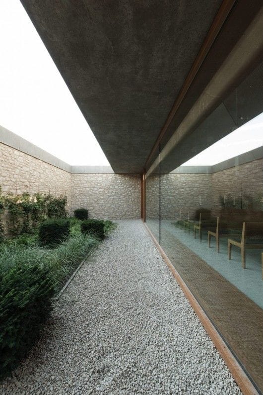 Отделка камнем сплошного забора в современном стиле